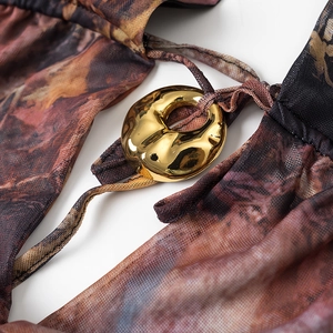 Detail showing the sheer mesh tie-dye fabric and the irregular golden metal buckle ring
