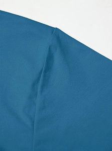 Detailed macro view of the shoulder seam and knit fabric of this blue Henley T-shirt