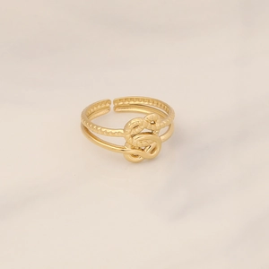 Detailed close-up of a double-layer golden knot ring with textured metallic band finish