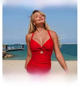 Detailed view of red one-piece swimsuit with halter neck knot and ruched waist design