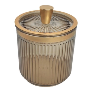 Elegant amber cotton swab holder with gold lid and vertical stripes on white background