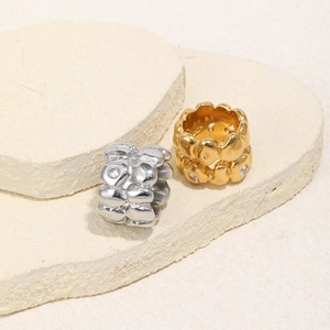 Detailed view of silver and gold wide rings with heart relief and sparkling stones