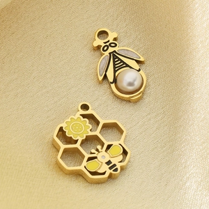 Detail of bee and honeycomb charms with white pearl and yellow enamel on gold silk