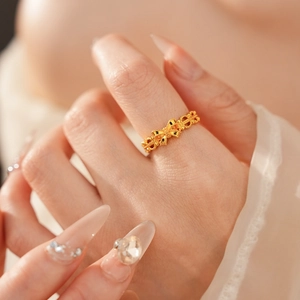 Detailed close-up of a vintage golden hollow woven ring with bow design on a model hand