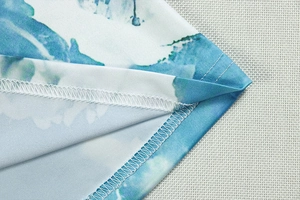 Detailed close-up of blue and white abstract print and professional hem stitching finish