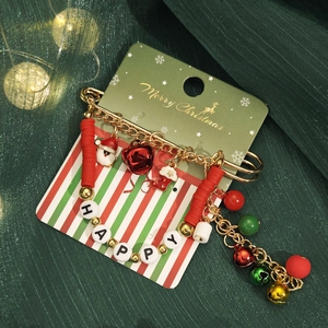 Détail du bracelet de Noël avec perles rouges et cloches sur carte de fête verte