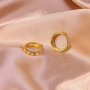 Macro shot of gold S925 sterling silver hoop earrings with sparkling inset diamonds