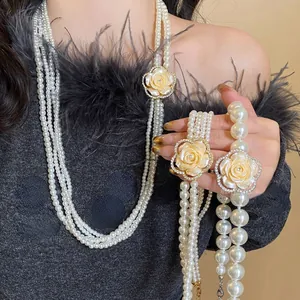 Detail of multilayer pearl necklace with a diamond-encrusted camellia flower pendant