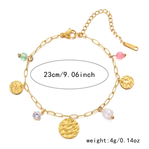 Détail du bracelet chaîne double rangée dorée avec perles et breloques en métal martelé