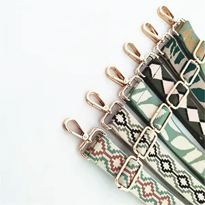 Detail of adjustable ethnic style bag straps with gold metal hooks and geometric patterns