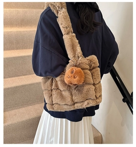 Detail of soft brown faux fur texture and cute plush bear charm on underarm shoulder bag