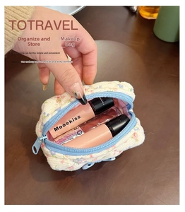Close-up of a floral quilted cotton makeup pouch with blue zipper and compact interior