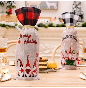 Detail of burlap Christmas wine gift bags with plaid trim and gnome festive patterns