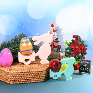 Gros plan sur des porte-œufs lapins de Pâques roses et verts avec des œufs décorés