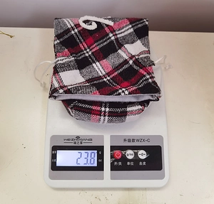 Vue détaillée du sac à vin de Noël à carreaux pesant 23,8 g sur une balance