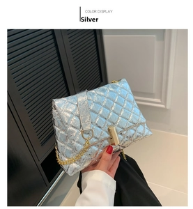 Detail of silver quilted handbag featuring gold metal chain and rectangular twist lock