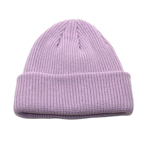 Macro detail of the light purple ribbed knit pattern and thick cuff of the winter beanie
