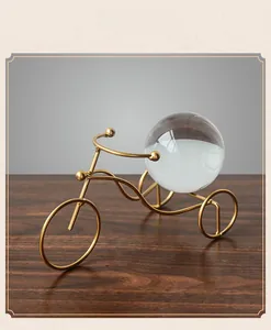 Detailed close-up of golden metal tricycle craft with a clear crystal ball on wooden desk