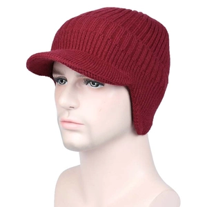 Detail of red knitted winter hat with visor and ear flaps on a display head model
