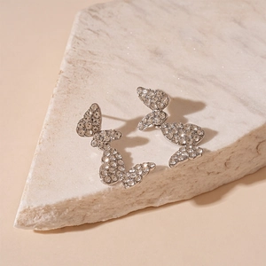 Elegant silver butterfly earrings featuring sparkling rhinestones on a stone base