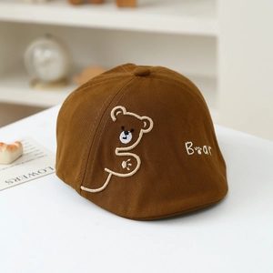 Detail of baby newsboy cap with bear embroidery and soft brown cotton twill fabric