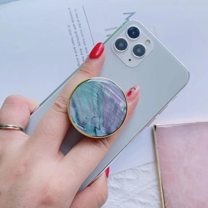 Detail of a marble textured phone socket with gold trim on a white smartphone