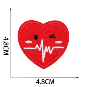 Macro detail of heart-shaped embroidery patch with ECG line and 4.8cm size markings