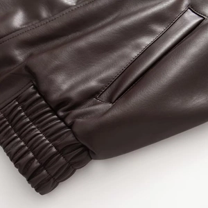 Fashionable dark brown leather jacket with elastic cuffs and side pockets close-up