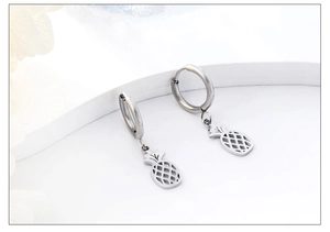 Close-up of silver pineapple hoop earrings featuring hollow tropical fruit charm