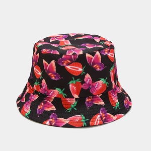 Detailed macro view of black canvas bucket hat with strawberry and butterfly patterns