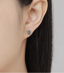 Macro side view of a round champagne gemstone earring set in a floral six-prong silver stud