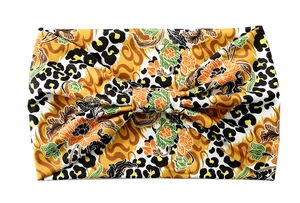 Close-up of stretchy yoga headband featuring leopard and floral prints with a twisted knot