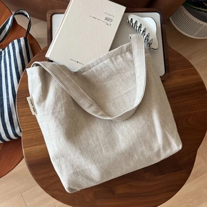 Minimalist beige linen tote bag with Simple Wish label on a rustic wooden table background
