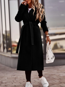 Detail of elegant black long wool coat with classic lapels and matching waist tie belt