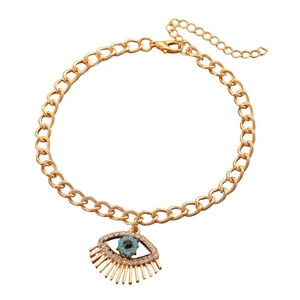 Close-up of golden evil eye anklet with blue rhinestones and lobster clasp closure