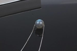 Macro shot of labradorite gemstone necklace with blue halo on silver chain