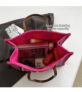 Detail of the woven tote bag interior showing the large capacity and leather handles