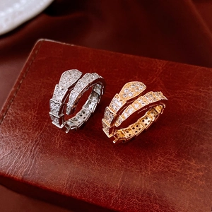 Détail de bagues serpent en argent et or avec zircons sur un écrin en cuir de luxe