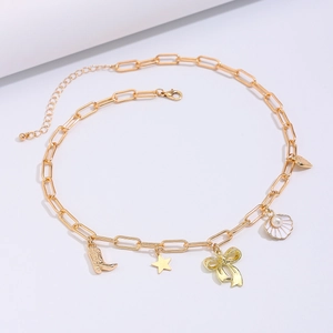 Detail of gold chain necklace with cowboy boot, star, bow and pearl shell charms