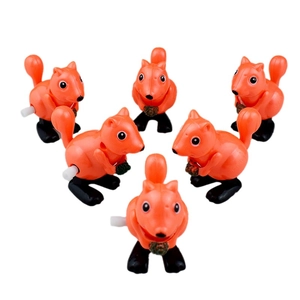 Detailed view of six orange wind-up jumping squirrel toys with acorns on white background