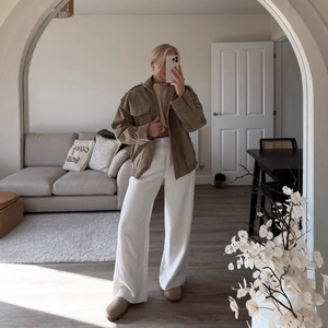 Brown corduroy jacket paired with white wide-leg trousers for a chic urban casual look