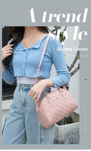 Détail d'un sac à main rose en similicuir matelassé avec fermoir fleur dorée et bandoulière