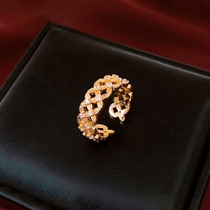 Détail d'une bague fleur ajourée plaquée or 18k avec zircon sur un écrin noir