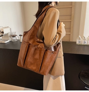 Brown retro PU leather tote bag worn with a beige blazer in a cozy cafe setting