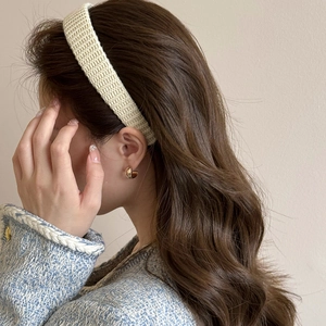 Detail of light beige knitted headband texture shown on a female model in side view