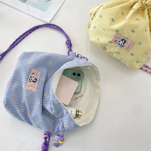 Detail of drawstring bags with colorful checkered patterns and cute panda patches