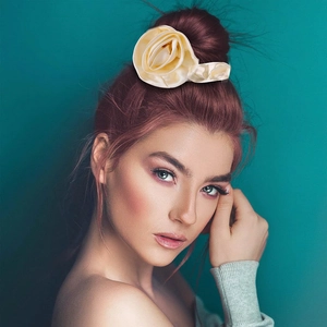 Elegant cream satin rose flower scrunchie hair tie on a model with auburn hair