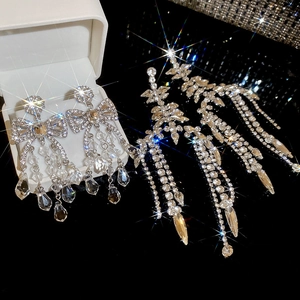 Macro shot of silver drop earrings with crystal tassels and sparkling leaf textures
