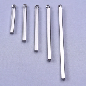Macro detail of five silver stainless steel bar pendants in varying lengths with jump rings