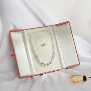 European vintage snap pearl jewelry box featuring a pearl necklace and diamond ring set